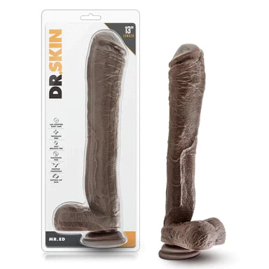 an extra long brown detailed penis shaped dildo with a thicker head, balls and a suction cup, shown next to its plastic packaging