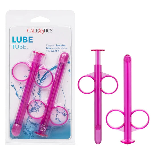 a pink lube dispensing syringe next to its additional tube, shown next to its plastic packaging