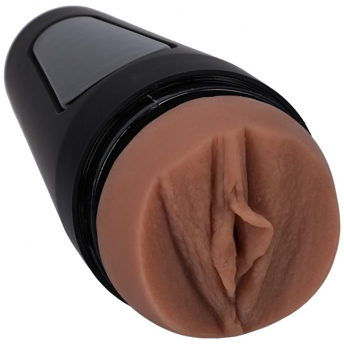 Image displays the vaginal opening of the tanned masturbator with the black hard shell 