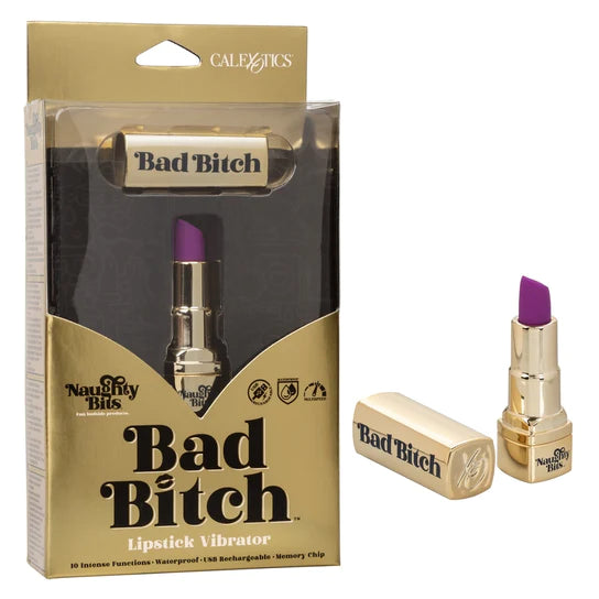 a gold lipstick vibrator with a slanted purple tip and gold cap with the words bad bitch on it shown next to its gold and clear packaging