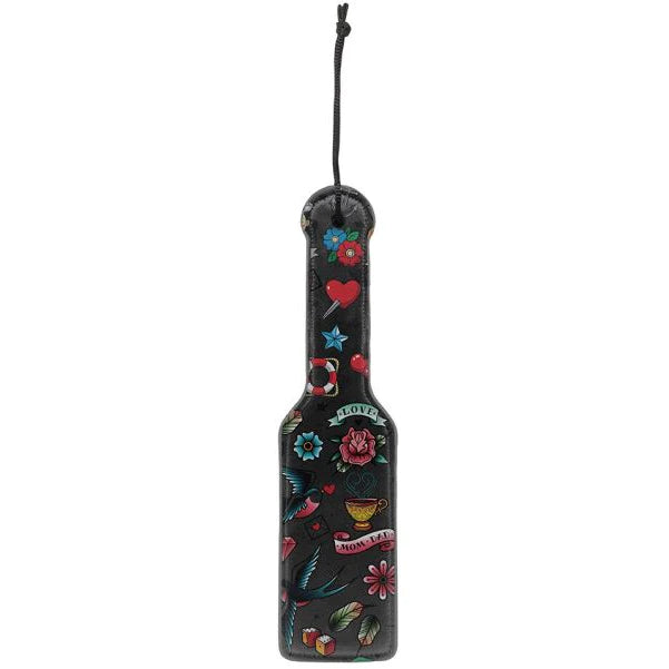 a black paddle with a pattern of vintage tattoos on it and a black wrist strap