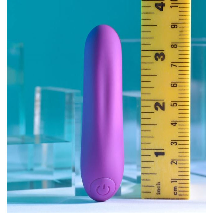 purple rechargeable vibrating bullet next to ruler for comparison