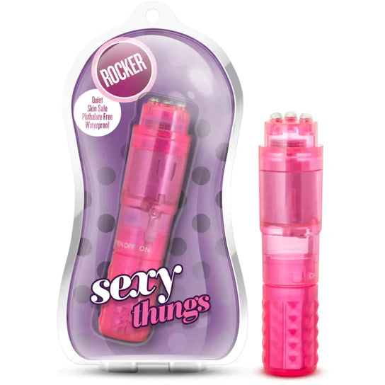 a pink clitoral vibrator with three silver balls on the flat top, shown next to its plastic packaging