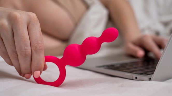 Photo of a person connecting their vibrator to their laptop