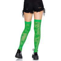 Green leaf-patterned thigh-high stockings worn with black shorts and black shoes on a white background