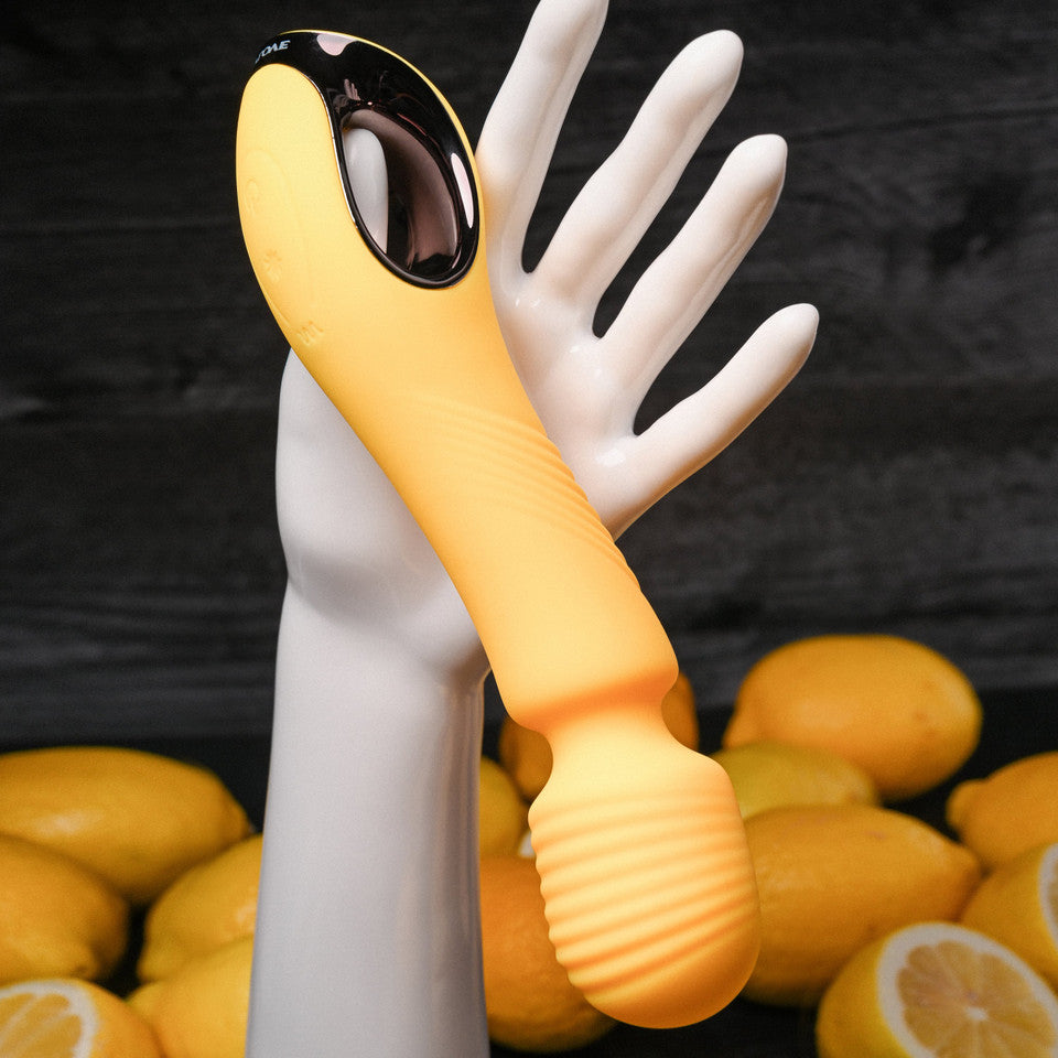 Yellow vibrating wand against hand example photo.