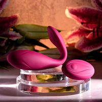 Pink cherry pose vibrator against display case with remote.