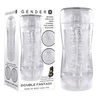 White Gender x package with a clear male masturbator shown beside it. There is a black vibrating cockring on the front of the package.