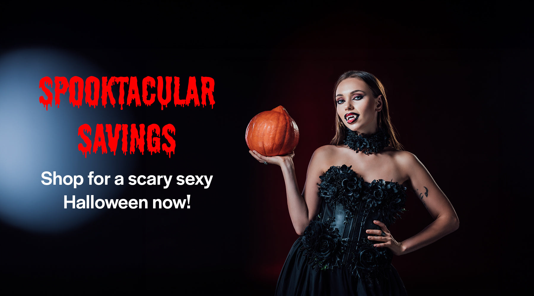 Beautiful woman holding pumpkin with vampire teeth