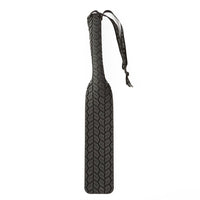 Black spanking paddle featuring textured surface and drawstring example photo.