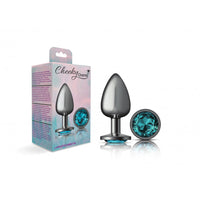Silver metal large with long blue gem beside packaging.