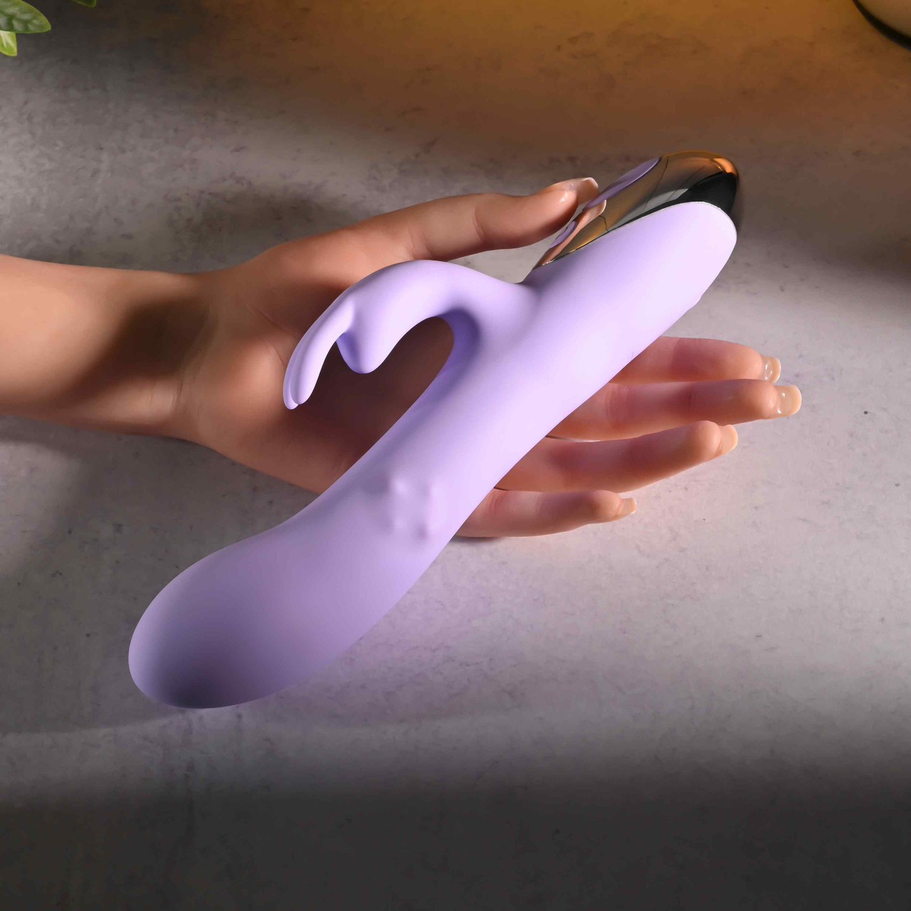 Purple vibrator against hand sizing photo.
