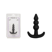 black anal plug with beads beside packaging