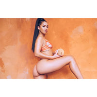 alina lopez in a bikini holding a fleshlight against an orange background