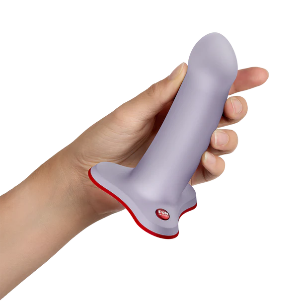 Hand holding a gray and red amor dildo device on a white background