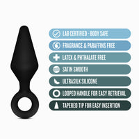 black anal plug with ring finger holder beside specs