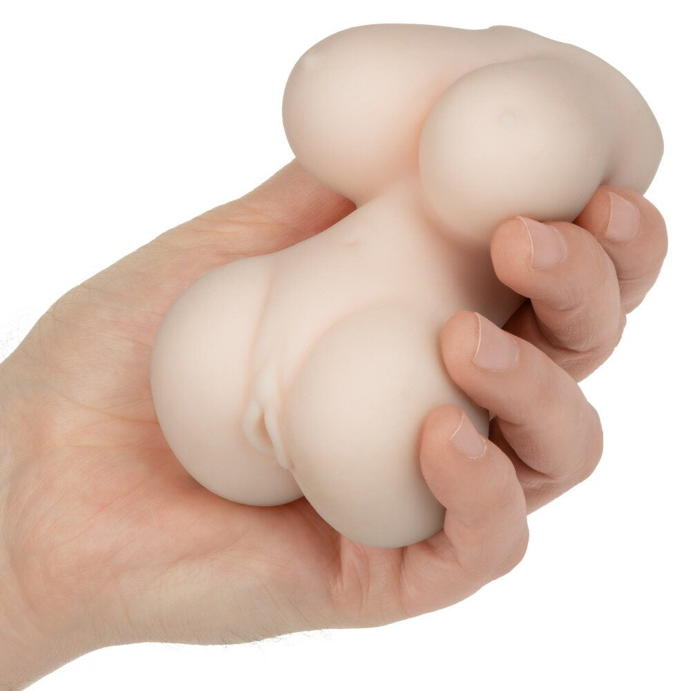 Hand holding a beige anime stroker trixie against a white background