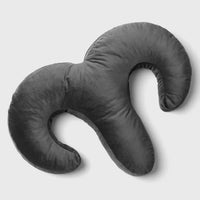 black arie shaped pillow on a light gray background