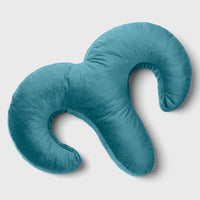 Teal arie shaped pillow on a light gray background