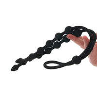 double ribbed anal beads held in hand on a white background