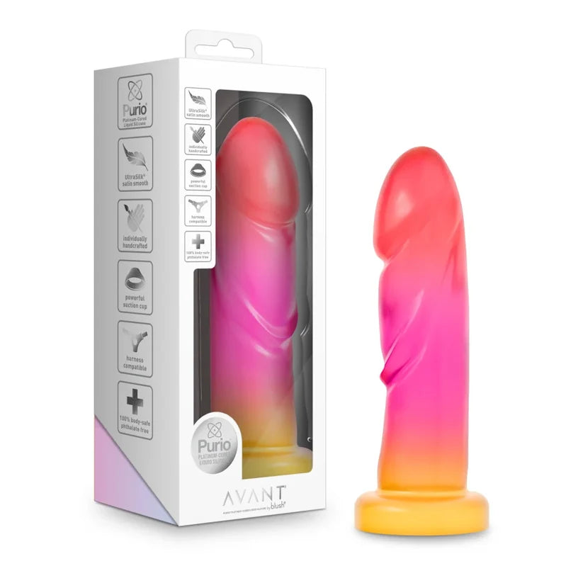 Avant brand sunburst dildo shown next to its retail packaging box. The product features a dual-color gradient transitioning from pink to orange and yellow, resting on a matching yellow base.
