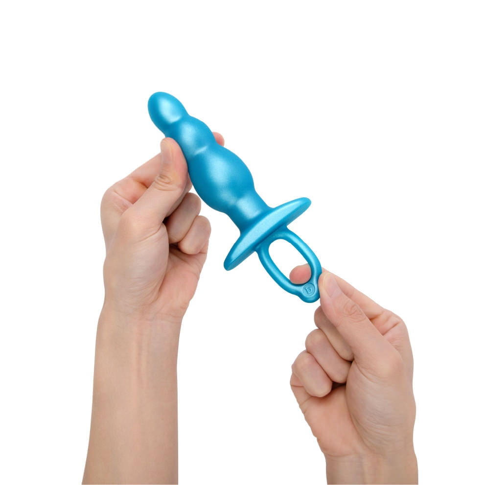 blue anal plug with finger ring held in 2 hands