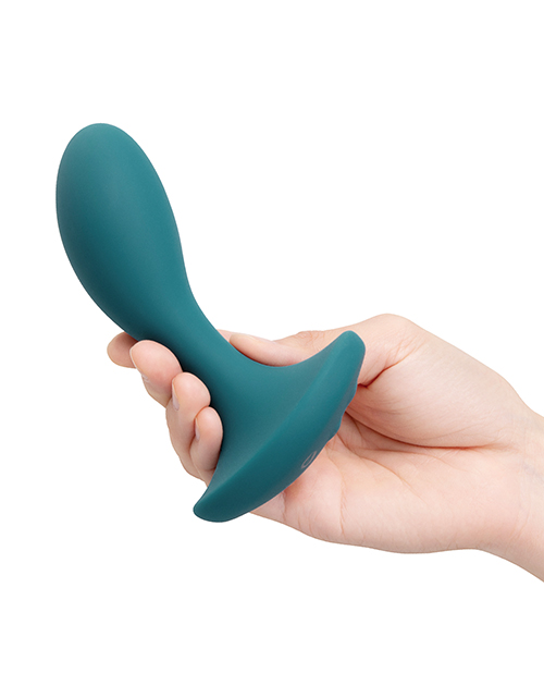 Teal silicone butt plug held in a hand against a white background