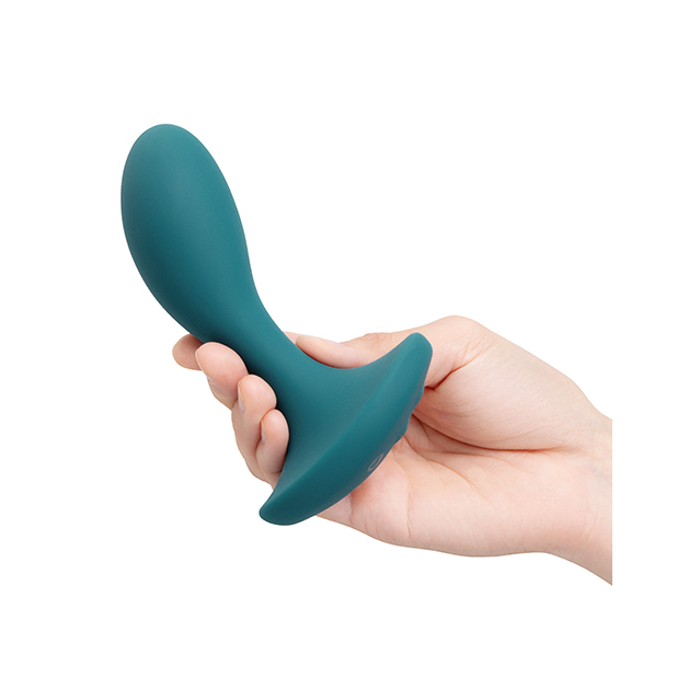 Teal silicone butt plug held in a hand against a white background