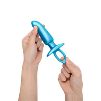 Blue butt plug held by two hands on a white background