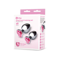 2 silver metal anal plugs with pink heart gems on bottoms. On box packaging