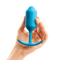 blue tapered anal plug with curved base, held in hand