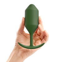 green tapered anal plug with curved bottom base, held in hand