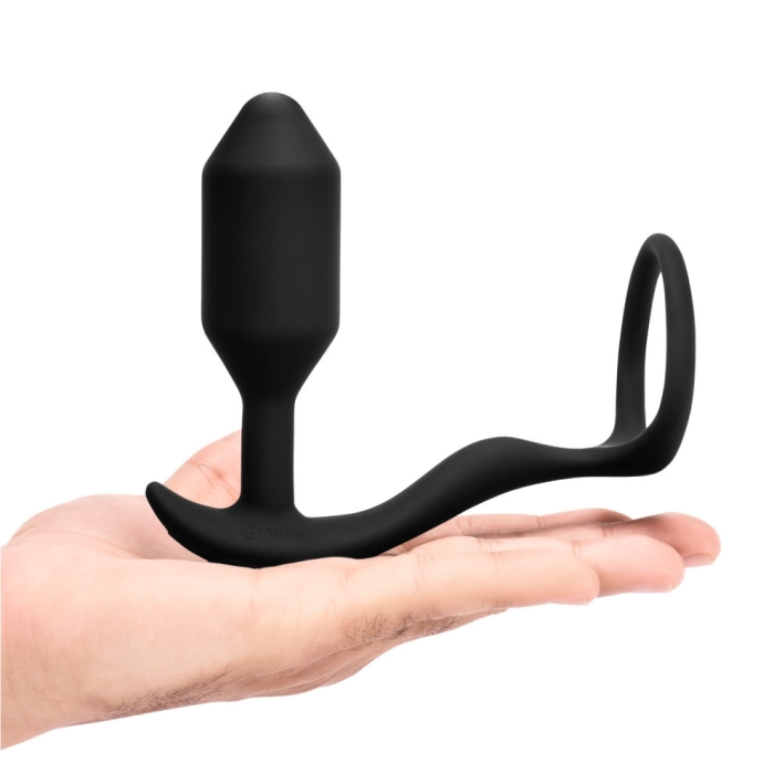 Black silicone butt plug held in a hand on a white background
