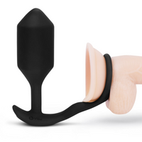Black silicone snug & tug anal plug product with 'b-Vibe' branding on a white background