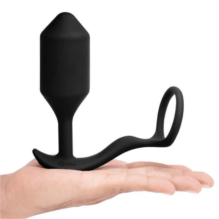 Black silicone butt plug held in a hand on a white background