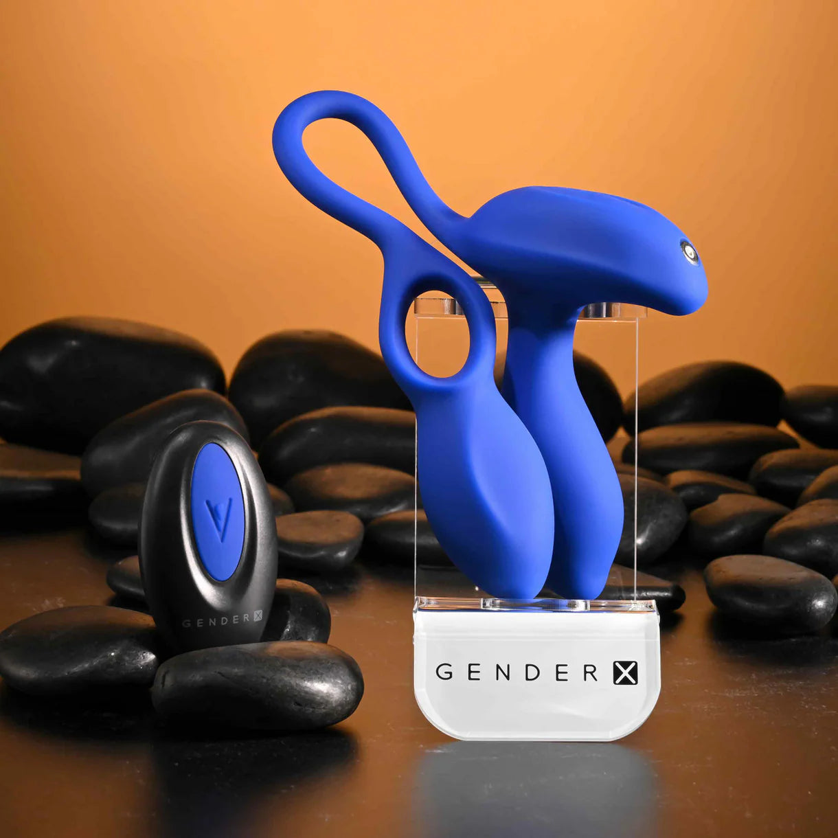 Blue anal plug with cock ring with 'GENDER X' branding on a brown background