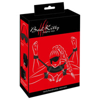 female silhouette laying on stomach, with ankle & wrist cuffs attached to neck support with blindfold on box packaging