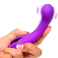 Purple handheld massager being held in a hand with a white background