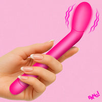 Hand holding a pink toy with a 'BANG!' logo on a pink background