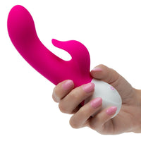 Pink and white rechargeable dual pleaser vibrator held by a hand with pink nail polish on a white background