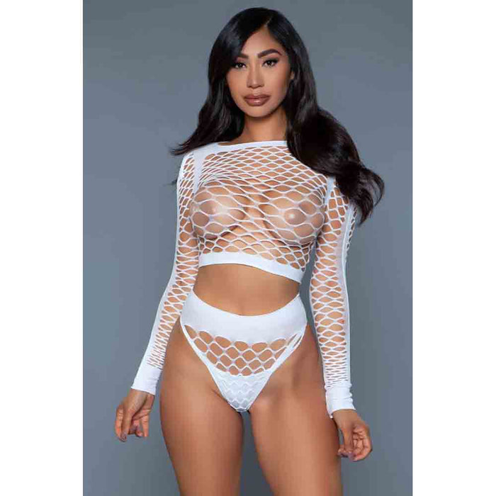 A model wearing a white long sleeve top and matching bottoms with a fishnet design.