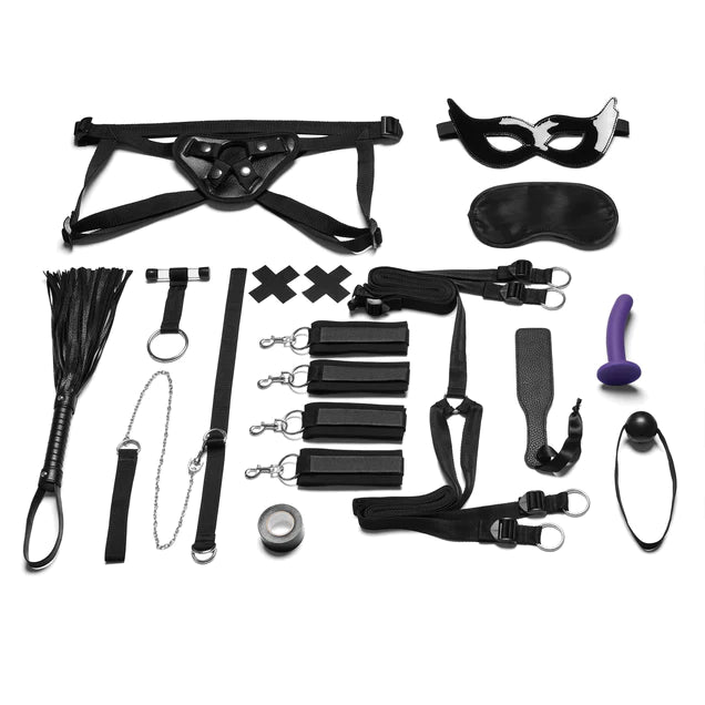a black bondage kit that includes a mask, a blindfold, a strap on set with a purple pegging dildo, a flogger, a leash, a collar, an over the door anchor strap, cross pasties, bondage tape, cuffs, under the mattress strap set, a paddle and a ball gag