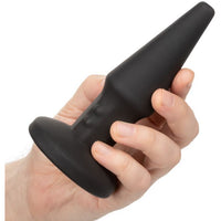 black anal plug held in hand on white background