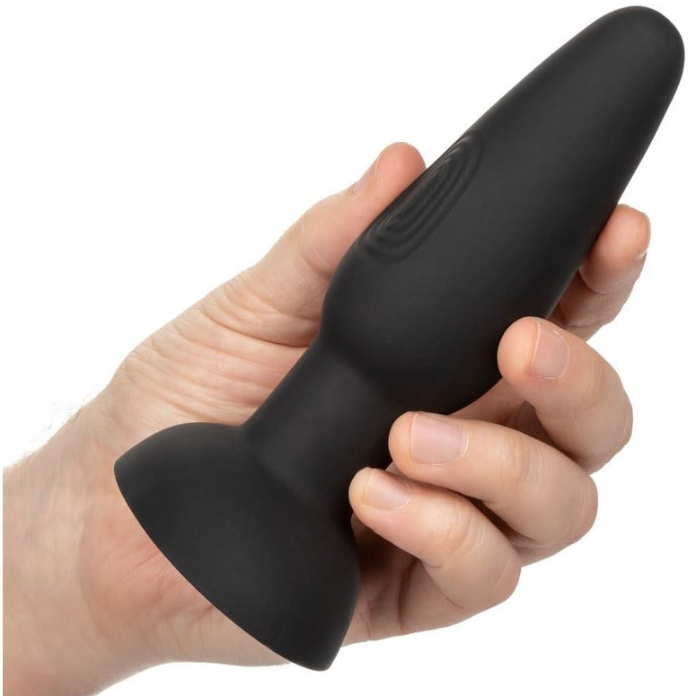 black anal plug held in hand on white background