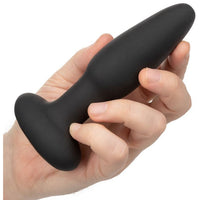 black anal plug held in hand on white background