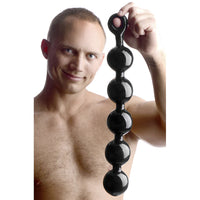 Man holding black massage balls against a white background
