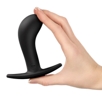 Black silicone anal plug held in a hand on a white background