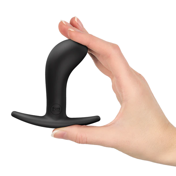 Black curved anal plug held in a hand against a white background