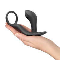Black silicone prostate massager held in a hand on a white background