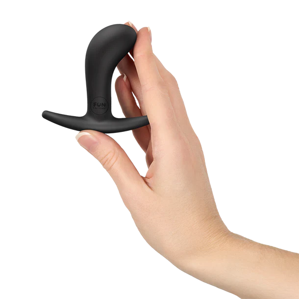 Black curved anal plug held in a hand against a white background